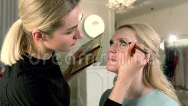 专业化妆师将完美的<strong>眼部</strong>化妆应用于美容院的金发女人。